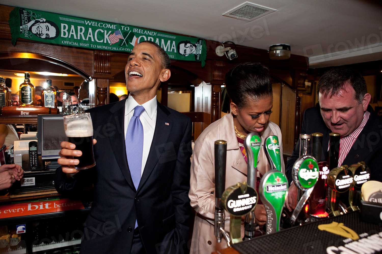 President Barack Obama talks with pub-goers as First Lady Michelle Obama draws a pint at Ollie Hayes pub in Moneygall, Ireland, May 23, 2011.