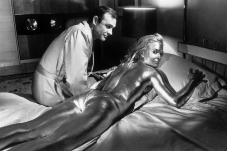 21st April 1964:  Sean Connery sitting beside his co-star English actress, Shirley Eaton, covered in gold during the filming of a scene from the James Bond film 'Goldfinger', directed by Guy Hamilton.  (Photo by Keystone/Getty Images)