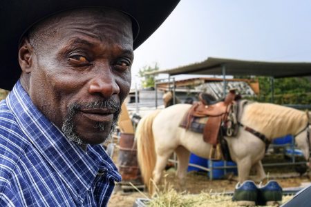 Ivory McCloud poses for a photo with his horse, Diamond, at his stable in the backyard of a home in Compton, Calif., on Sunday, Aug. 7, 2016. "I've got 40 years in this, man," the 56-year-old horseman says. "My dad was a cowboy. I'm a cowboy. I grew up in Compton. I live in Compton and I've been training horses since I was a kid." (AP Photo/Richard Vogel)