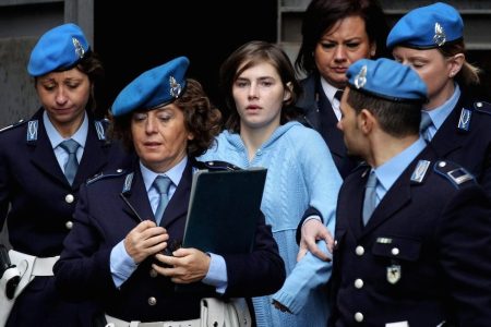 PERUGIA, ITALY - NOVEMBER 24:  Amanda Knox (C) is led away from Perugia's Court of Appeal by police officers after the first session of her appeal against her murder conviction on November 24, 2010 in Perugia, Italy. American Amanda Knox and her Italian ex-boyfriend Raffaele Sollecito were convicted of the murder of Ms Knox's former British flatmate Meredith Kercher in 2007. Their initial trial completed in December 2009 with Knox and Sollecito receiving sentences of 26 and 25 years respectively. Rudy Guede, an unemployed man from Ivory Coast, was also convicted of the murder of Meredith Kercher. The case is also forming the basis for a film currently being shot in Italy entitled 'The Amanda Knox Story', with American actress Hayden Panettiere cast as Amanda Knox.  (Photo by Oli Scarff/Getty Images)