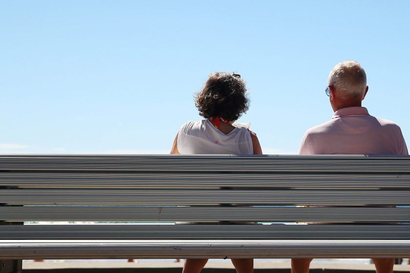 A woman and a man look out towards the beach while sitting on a bench in Sydney, Australia, on Wednesday, April 1, 2015. The number of people in Australia aged 65 and over is expected to double by 2055. (Brendon Thorne/Bloomberg via Getty Images