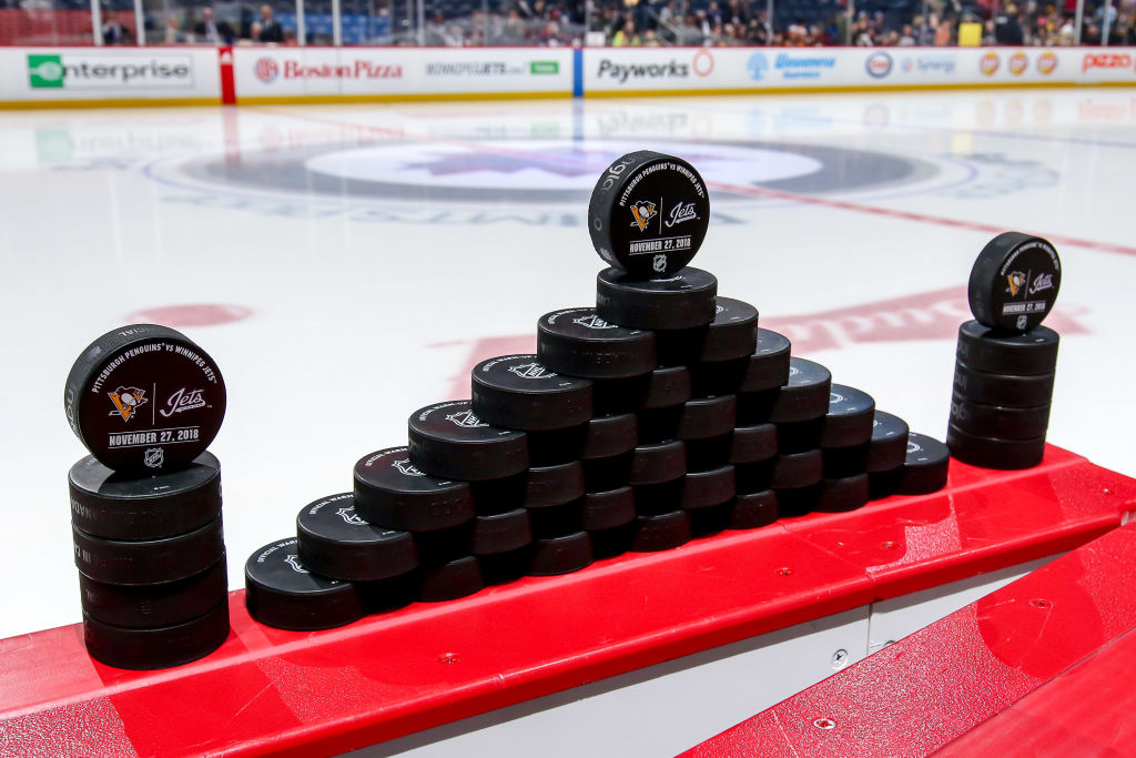 WINNIPEG, MB - NOVEMBER 27: Warm up pucks are lined up and ready for the start of the pre-game warm up prior to NHL action between the Winnipeg Jets and the Pittsburgh Penguins at the Bell MTS Place on November 27, 2018 in Winnipeg, Manitoba, Canada. (Photo by Jonathan Kozub/NHLI via Getty Images)