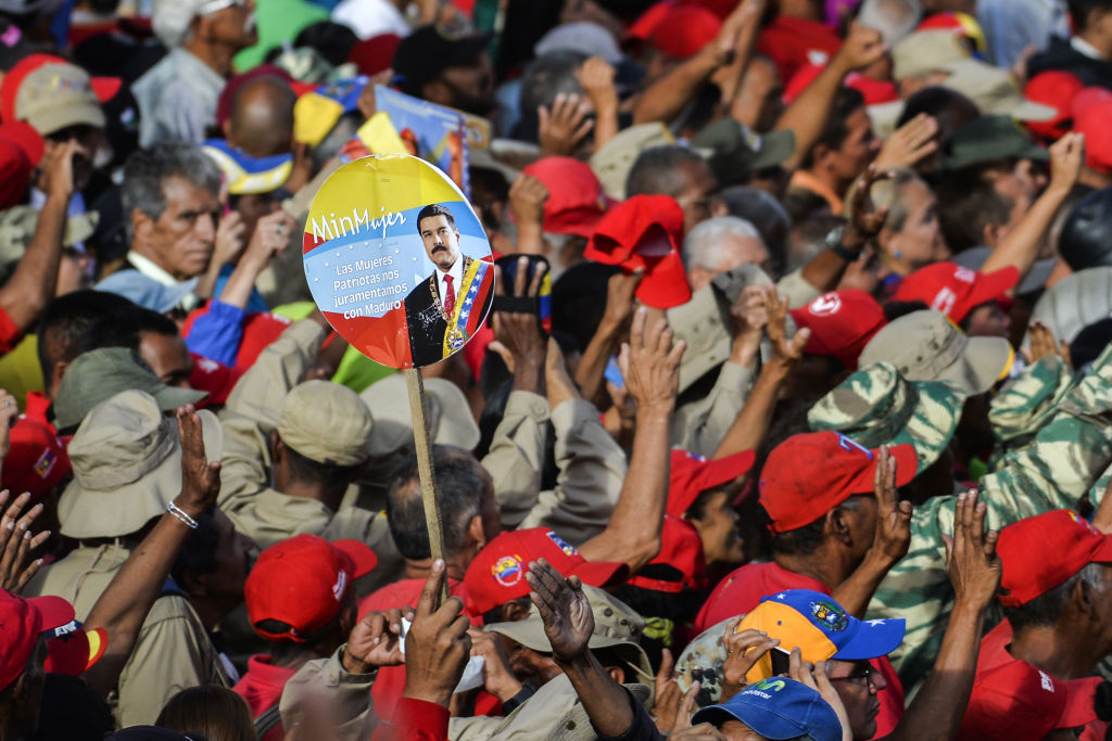 TOPSHOT - Government supporters listen to Venezuelan President Nicolas Maduro speaking at the Miraflores Palace during a rally in which he announced that his administration was breaking off diplomatic ties with the United States, in Caracas on January 23, 2019. - Venezuelan President Nicolas Maduro announced on Wednesday he was breaking off diplomatic ties with the United States after his counterpart Donald Trump acknowledged opposition leader Juan Guaido as the South American country's "interim president." (Photo by Luis ROBAYO / AFP)        (Photo credit should read LUIS ROBAYO/AFP/Getty Images)