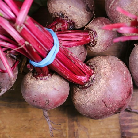 A photo of beets taken from the ground and tied together.