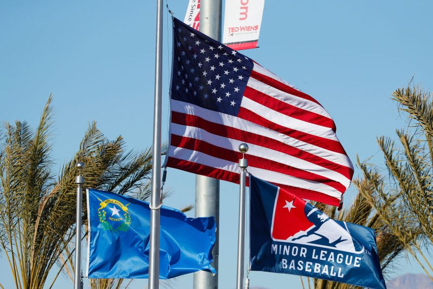 An American flag waving alongside a Minor League Baseball flag