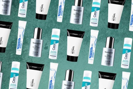 A collection of bottles of topical retinol on a green background.