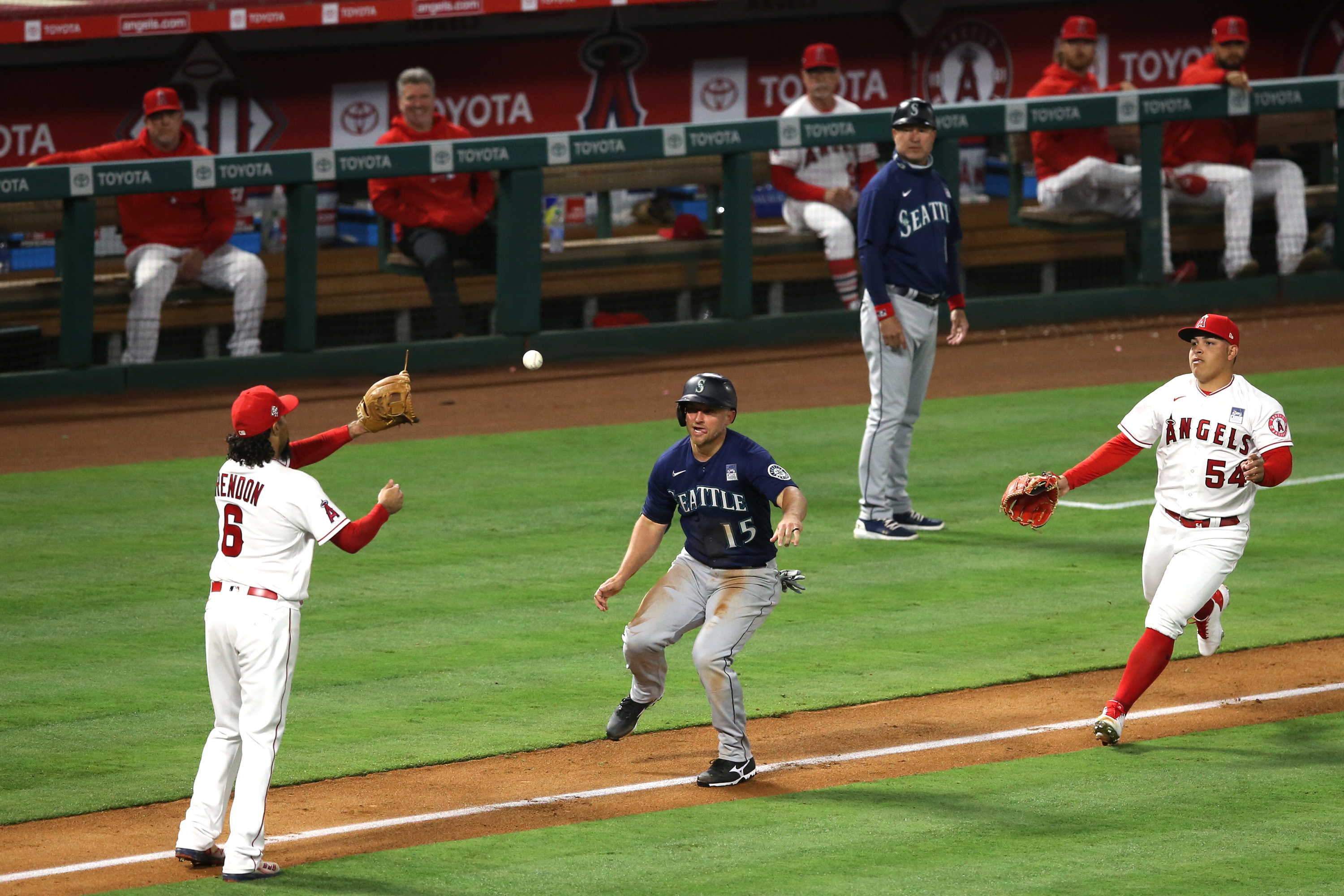 ANAHEIM, CALIFORNIA - JUNE 03: Kyle Seager #15 of the Seattle Mariners is caught in a rundown between Anthony Rendon #6 and Jose Suarez #54 of the Los Angeles Angels after stealing third base in the fifth inning at Angel Stadium of Anaheim on June 03, 2021 in Anaheim, California.
