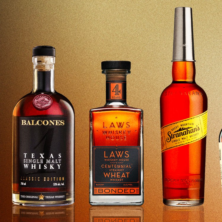 a line of whiskey bottles including elijah craig, balcones, laws, stranahan and makers mark