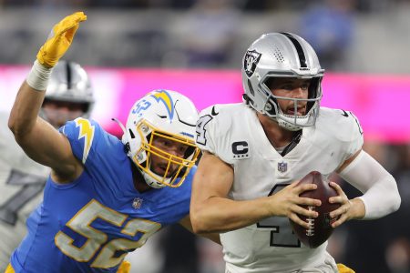 Derek Carr of the Raiders is tackled by Kyler Fackrell of the Chargers