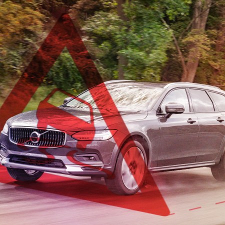 A warning sign hovers in front of the 2022 Volvo V90 Cross Country as it drives down the road. We tested the station wagon's semi-autonomous Pilot Assist system on a road trip.