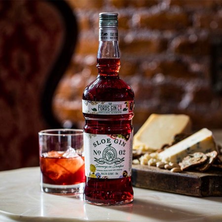 Fords Sloe Gin, a cocktail and a cheese board on a table. Fords Sloe Gin is a new release and an updated take on a classic UK liqueur.