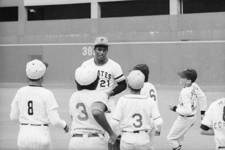 Roberto Clemente talks with kid ballplayers at his home field