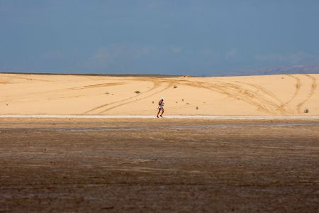 A man running across a desert in Tunisia.