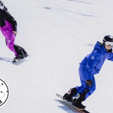 Two snowboarders going down a mountain.