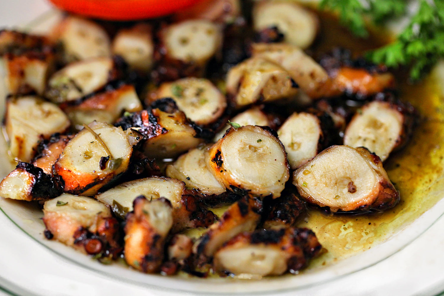a closeup of sliced chargrilled octopus in lemon and olive oil