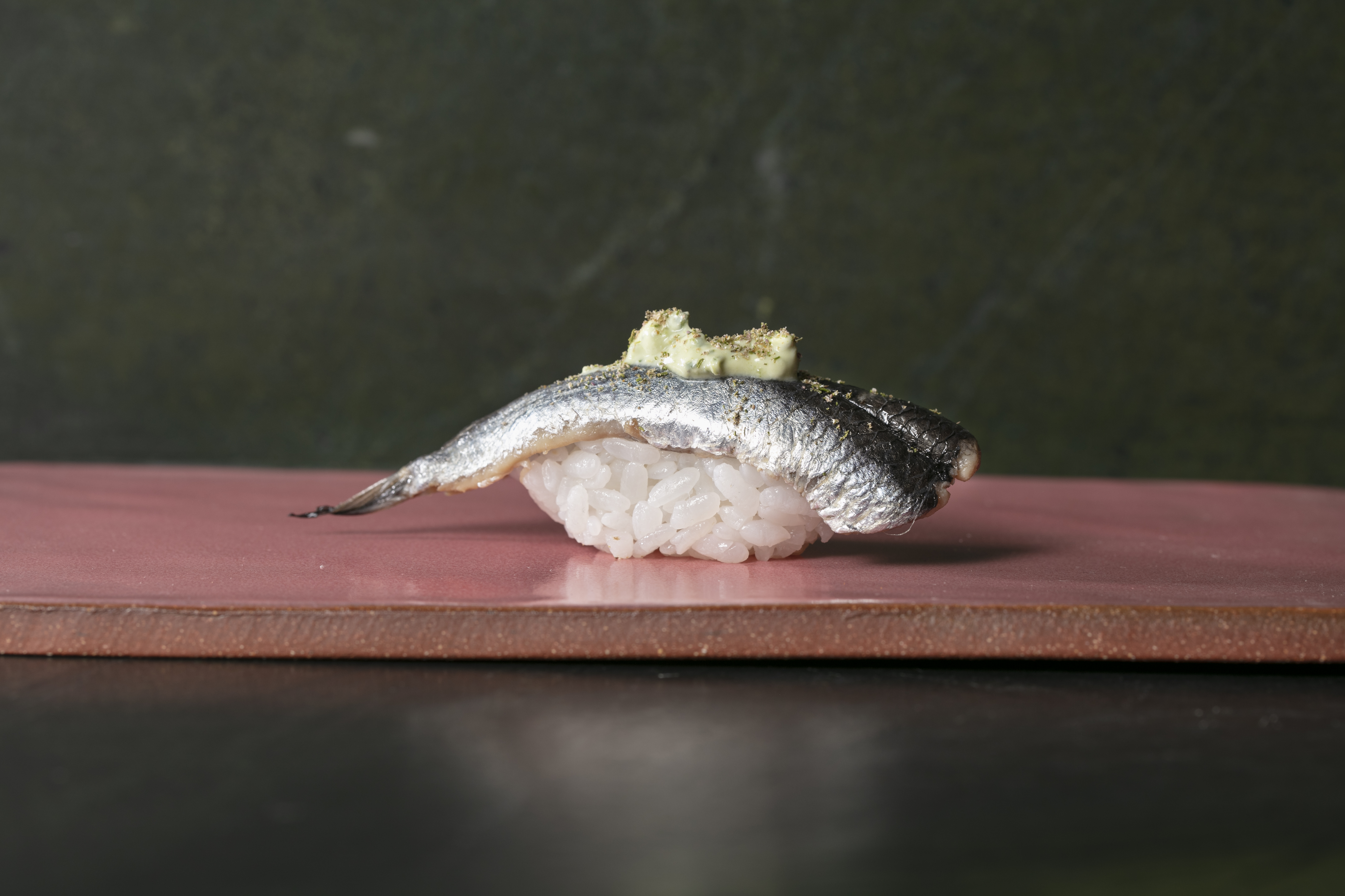 nigiri with green sauce on a board