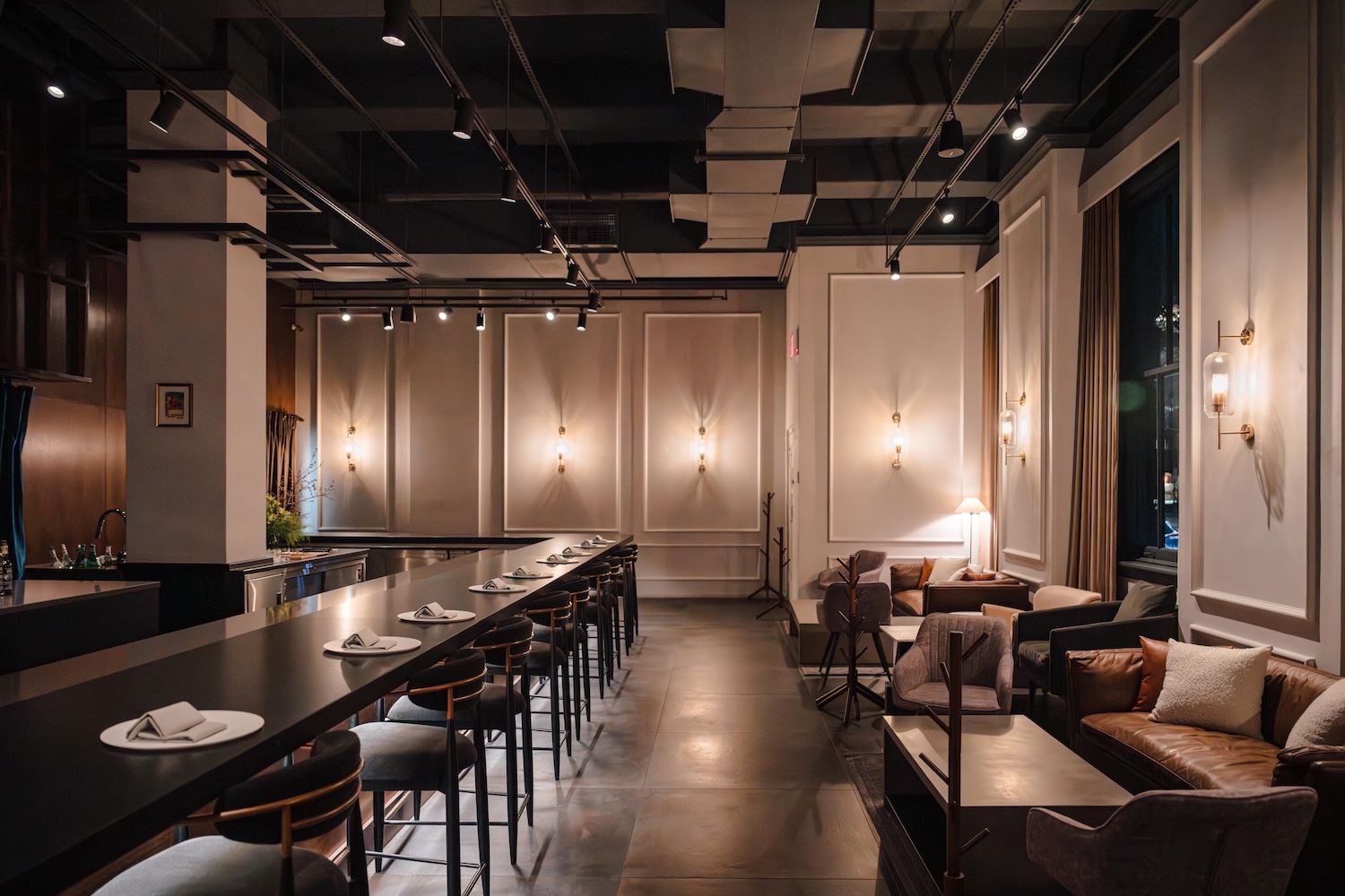 long table with stools, white walls, other tables