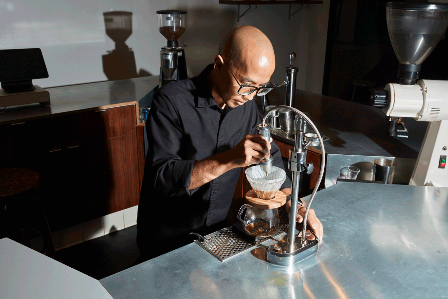 bald barista pouring coffee