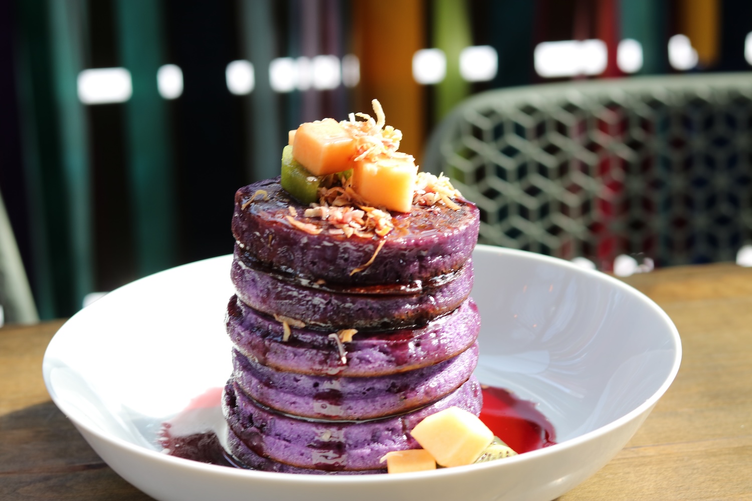 purple pancake stack with fruits and syrup on top