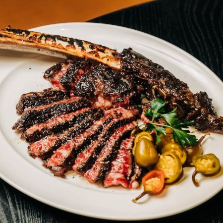 A tomahawk steak from RPM, garnished with jalapeño peppers.