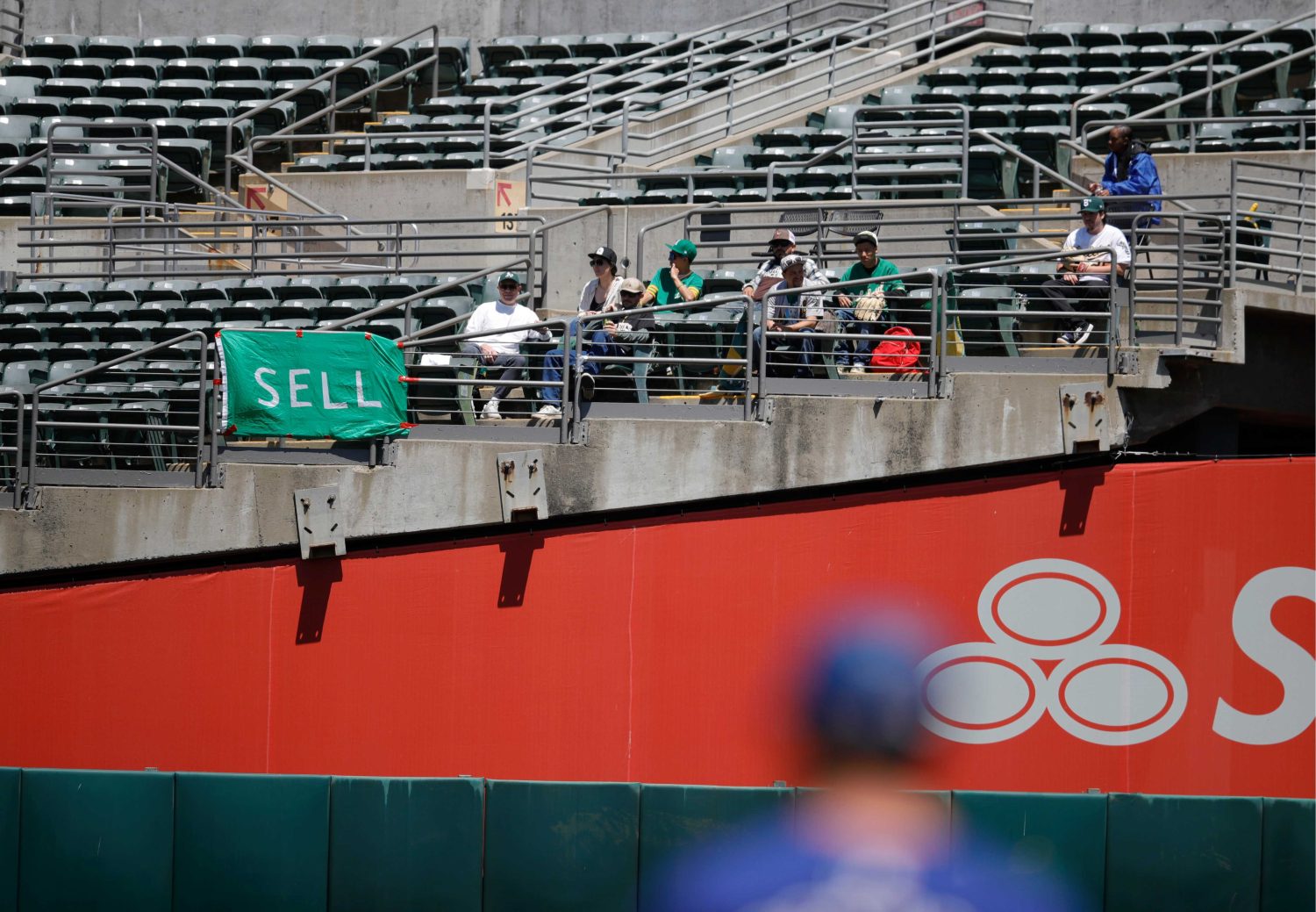 Oakland Athletics fans with signs begging ownership to sell the team.