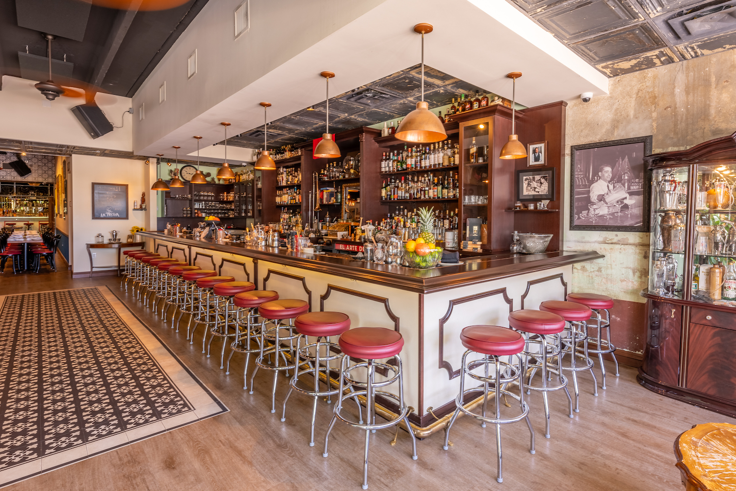 a brown and white bar surrounded by red lather bar stools