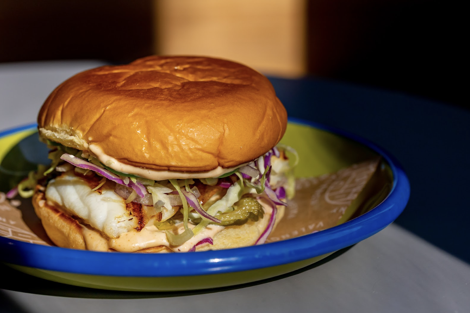 Fort Point's "Grilled Halibut Sandwich," stacked with slaw, pickles and remoulade on a toasted bun