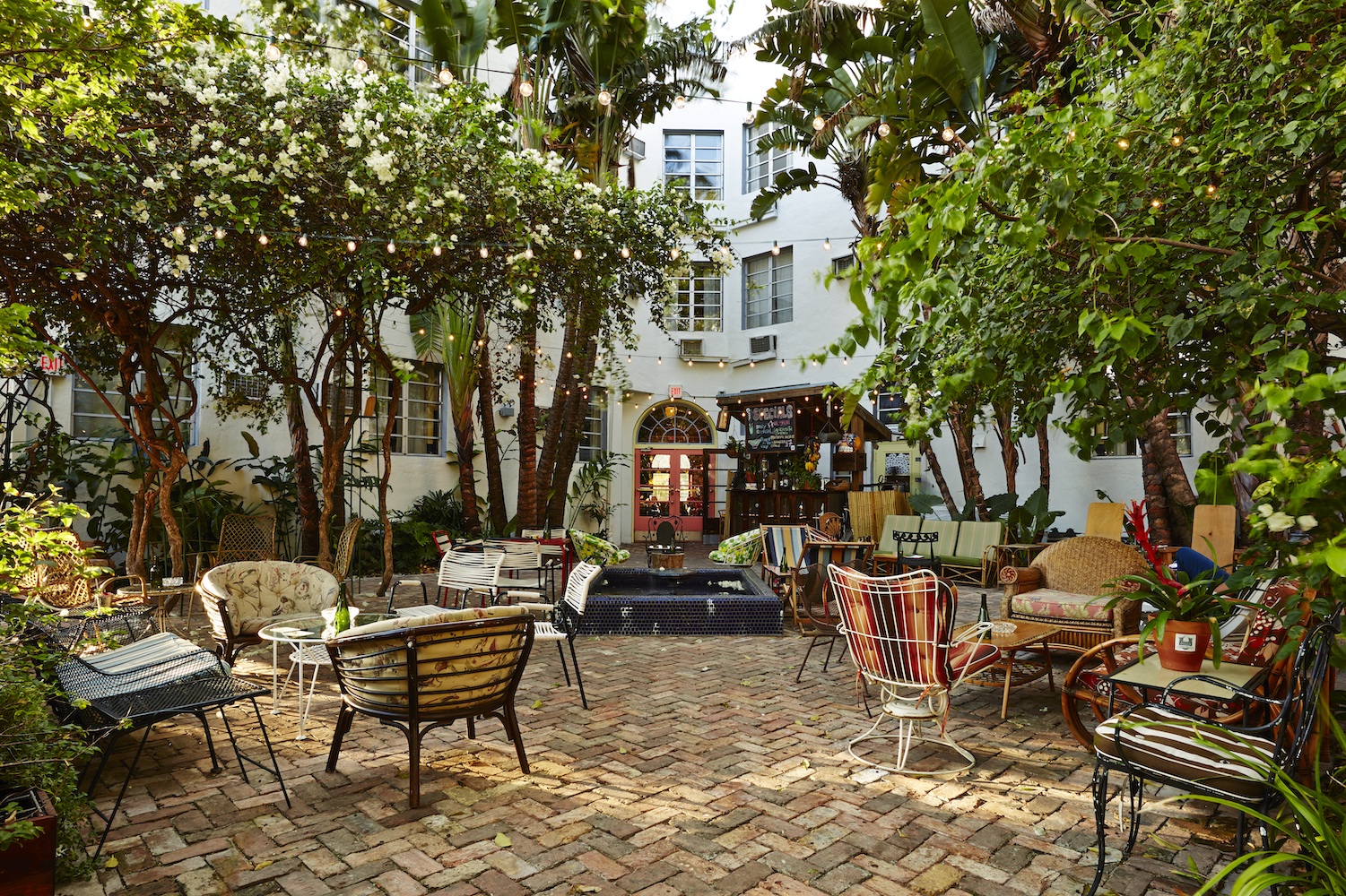 a verdant courtyard filled with trees and patio furniture