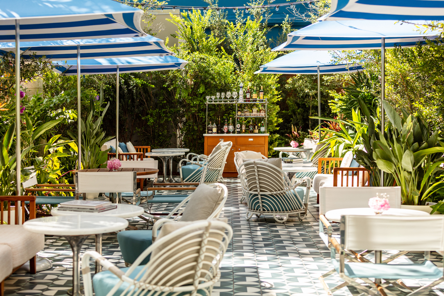 a patio restaurant with blue and white striped umbrellas and lots of greenery