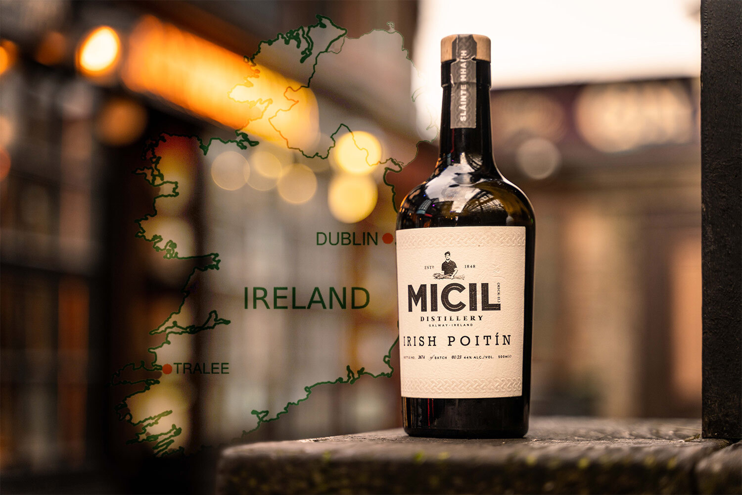 A bottle of Micil Poitín against a blurry background and a map of Ireland