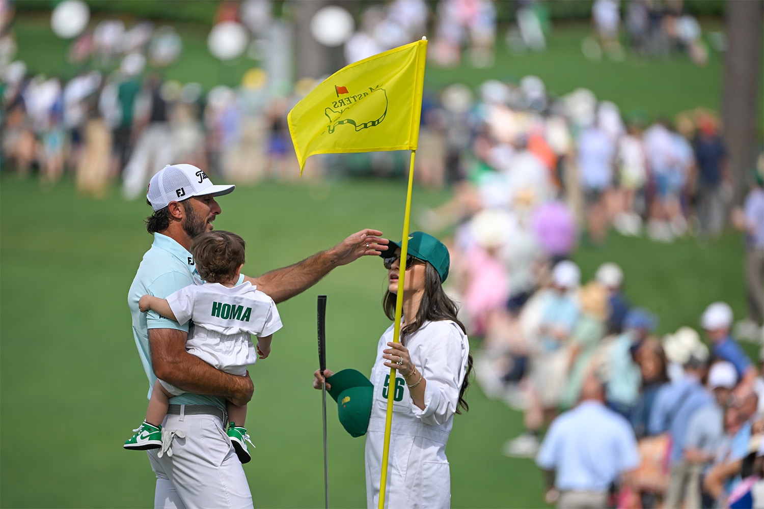 Max Homa holding his baby and standing next to his wife at The Masters.