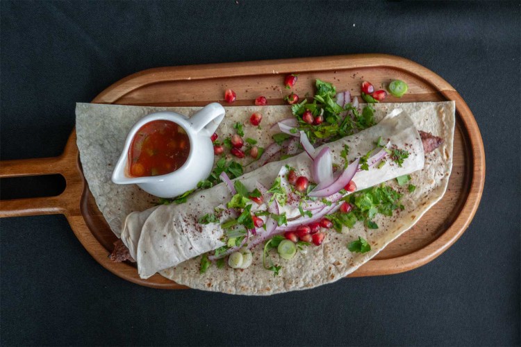 X Factory's signature kebab, featuring beef and pork wrapped in a thin layer of bread and topped with onion, pomegranate and cilantro