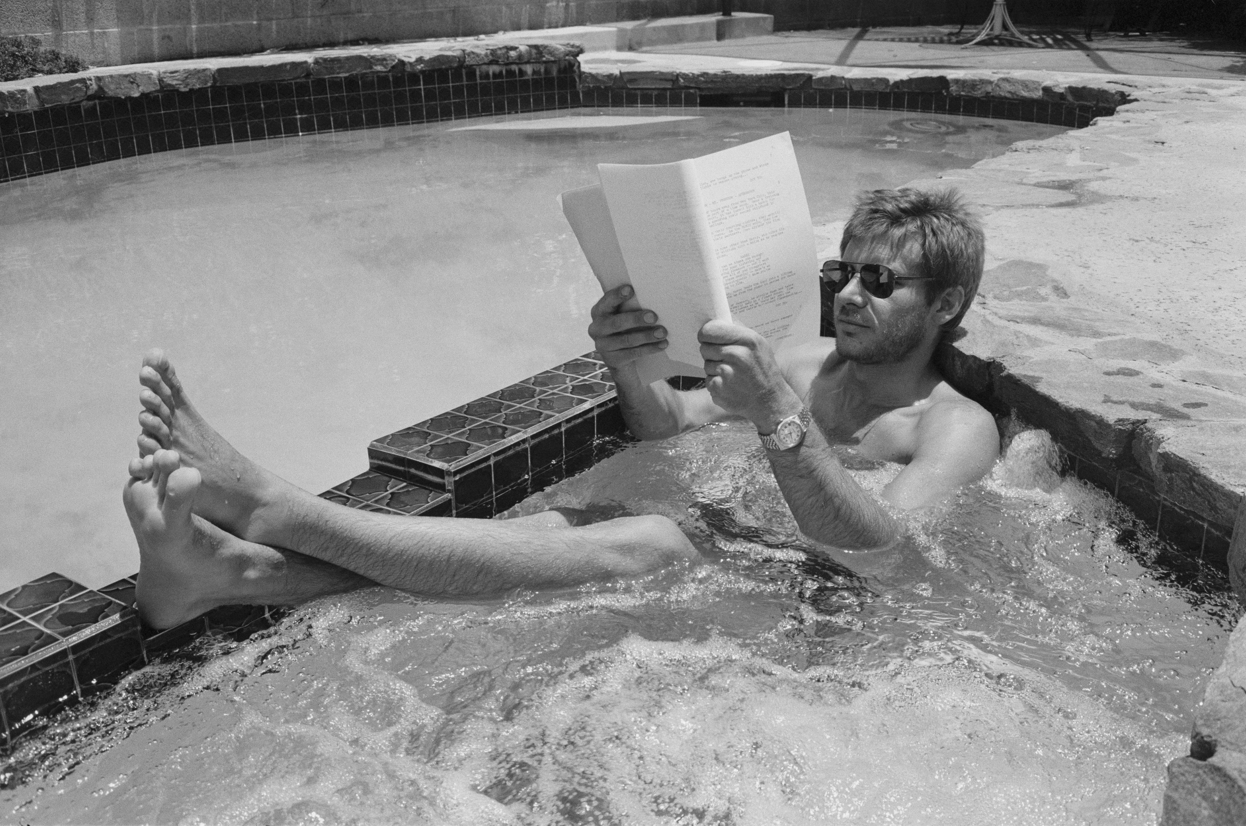 A shot of Harrison Ford reading a script in a hot tub.