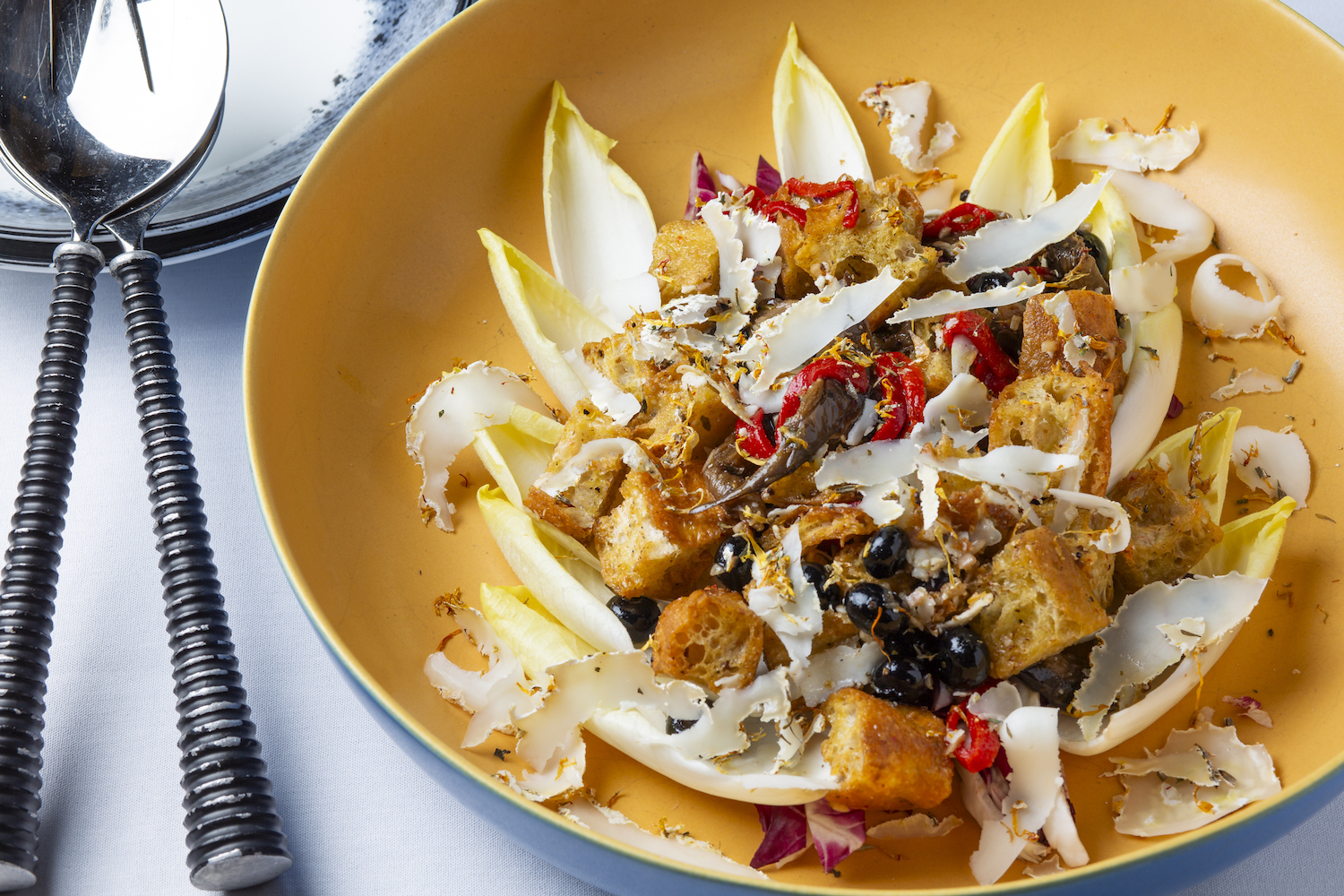 A radicchio panzanella salad with blueberries and goat cheese in a yellow bowl, from Chef Greg Wade of Publican Quality Bread