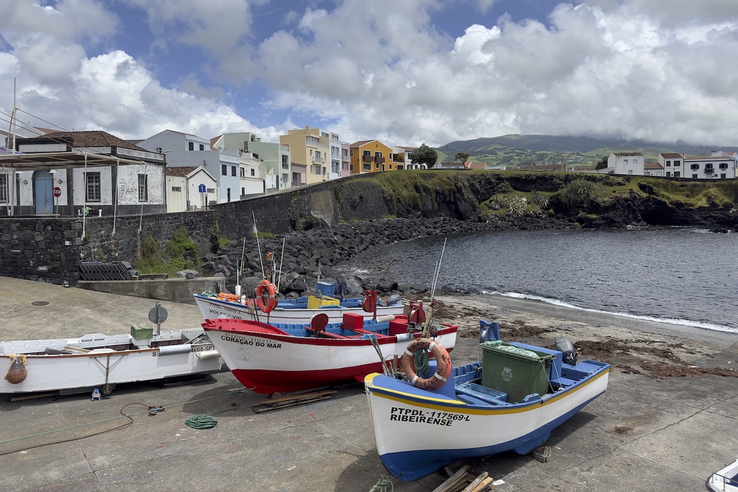 two boats in front of the water with houses in the background