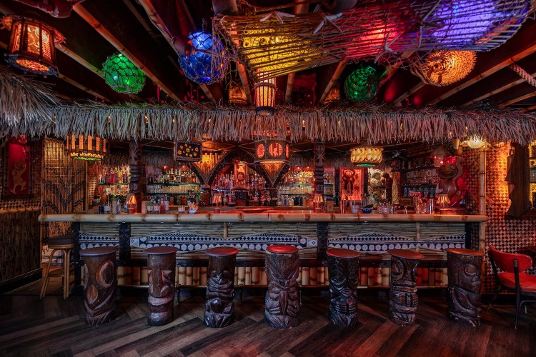 Interior of Lucky Tiki, decorated in bamboo decor and colorful lighting