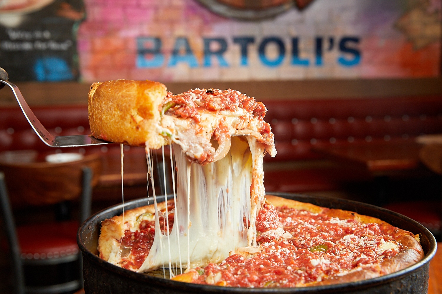 Slice of pizza being pulled out from a whole pie