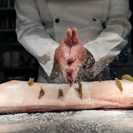 A pro chef salts the Danish dish flæskesteg, a celebratory roast pork