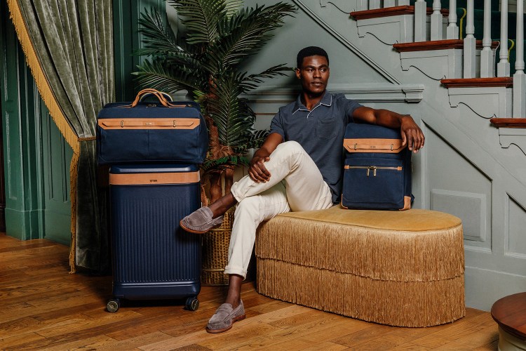 A man sitting with luggage from the new Hartmann Reserve Collection