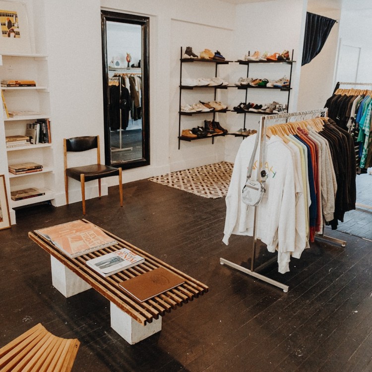 Clothing racks and shelves of shoes and a mirror inside of ReLove