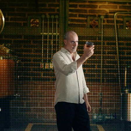 Iván Saldaña of Casa Lumbre inspecting a glass near a still