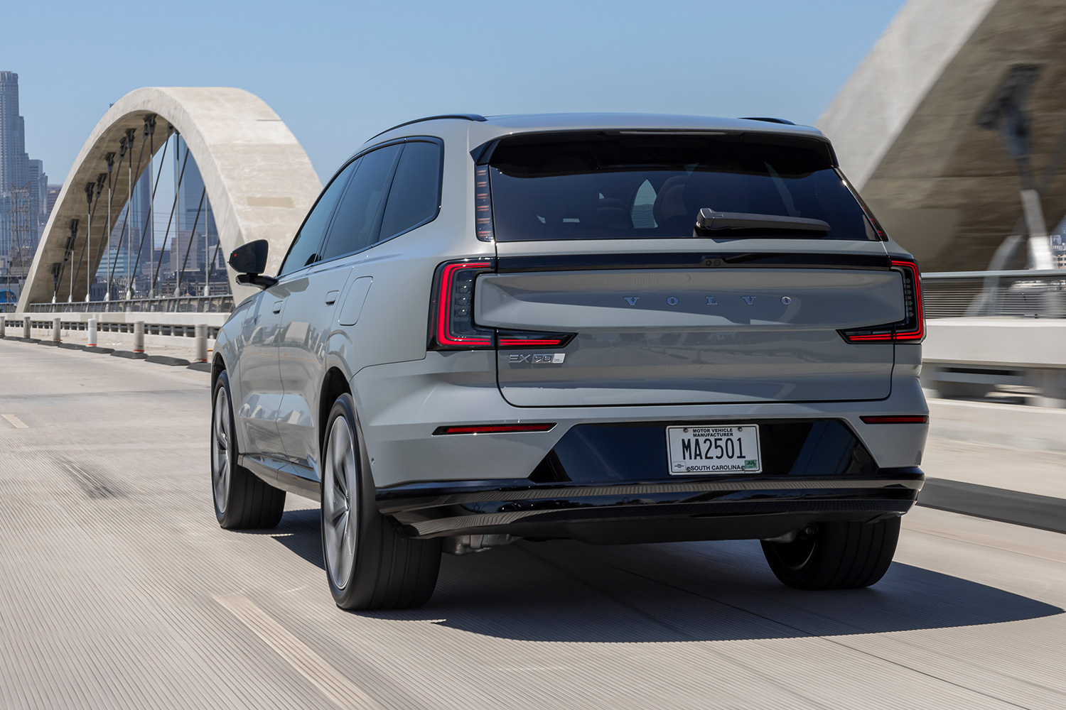 The rear end of the Volvo EX90 SUV seen while it drives down the road