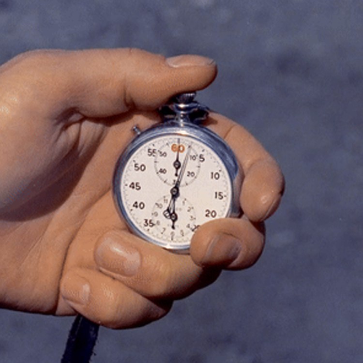 A man pressing an old-fashioned stopwatch.