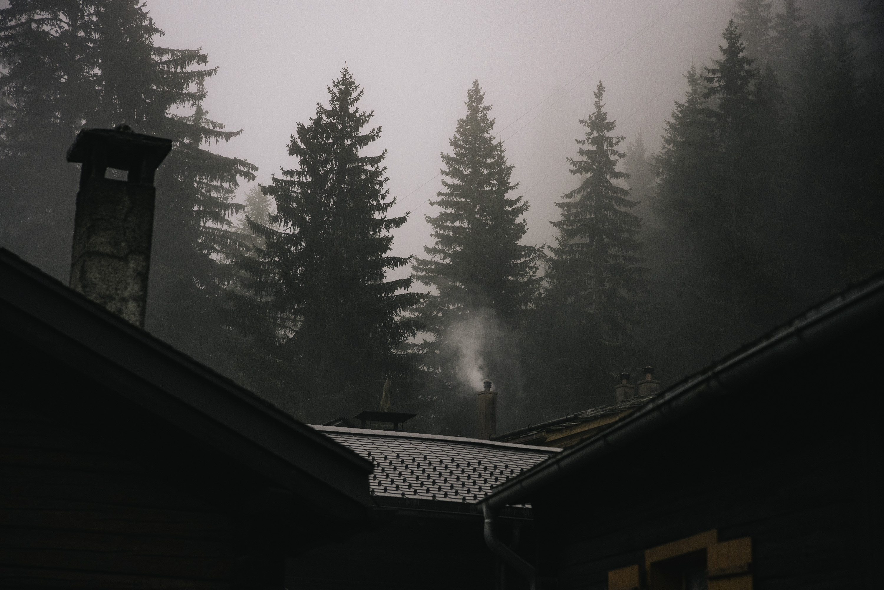 Smoke emanates from the chimney of a Swiss hut.