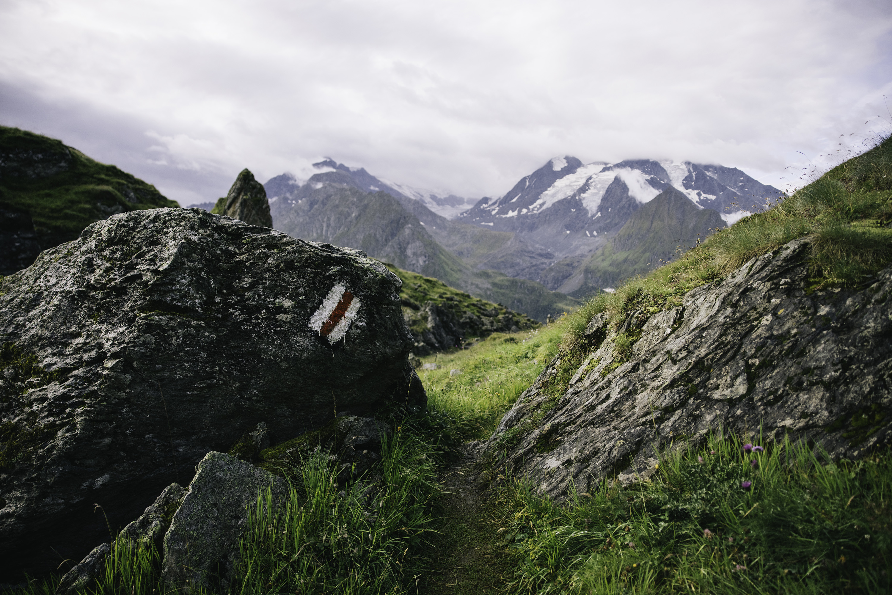 A trail passing through two rocks in the Swiss Alps.