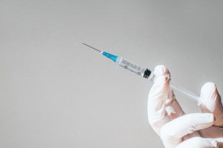 Hand holding syringe