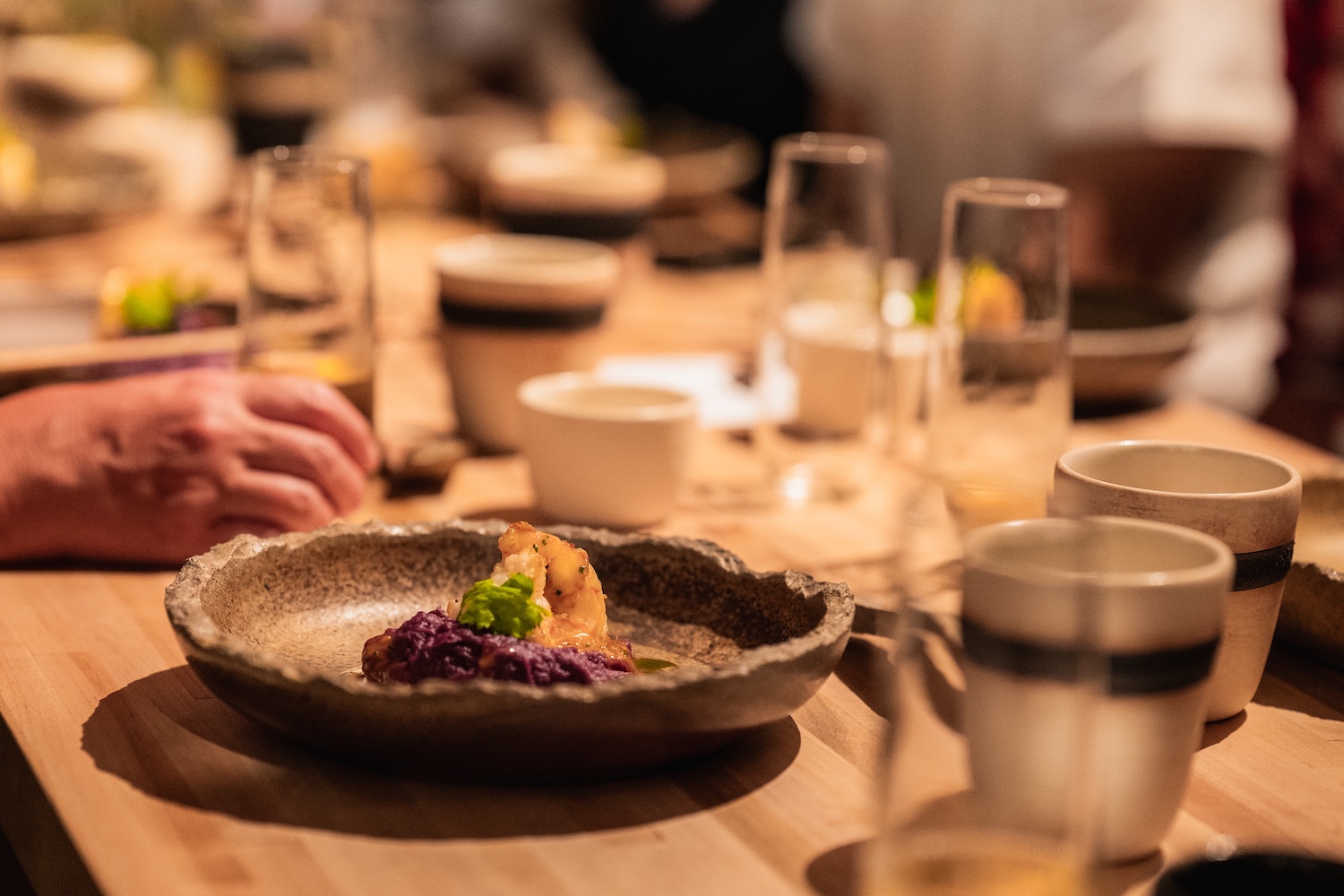 a shrimp dish on a rustic ceramic plate on a wooden table