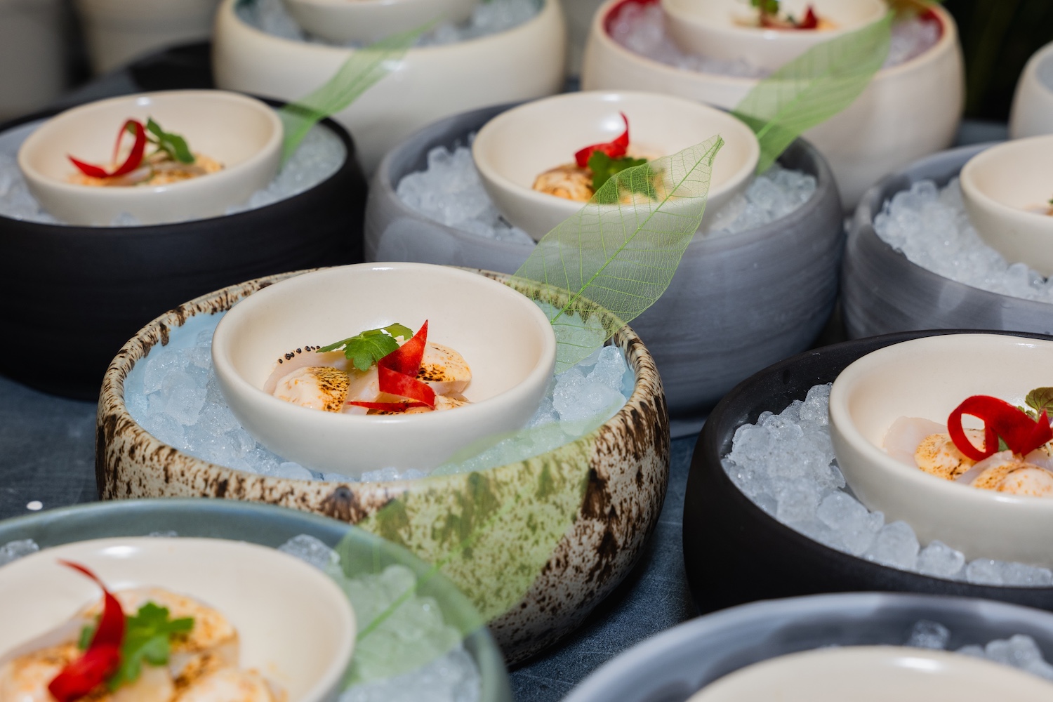 a seafood small plate in a little white bowl on ice inside a bigger ceramic bowl