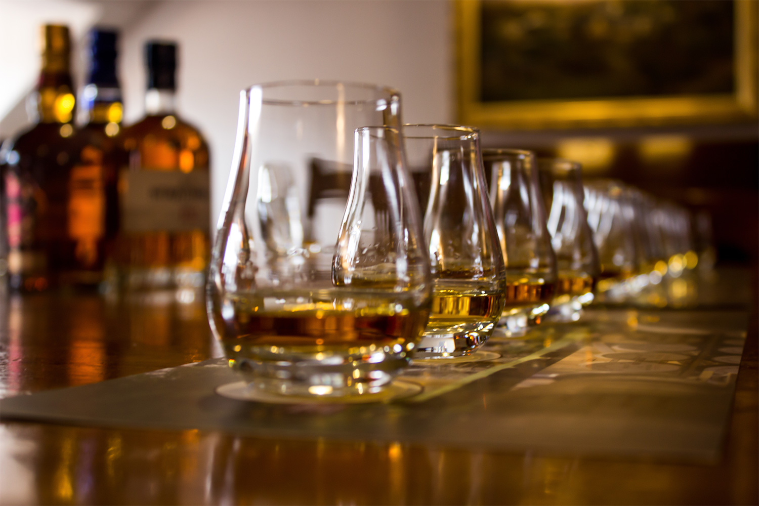 a line of glencairn glasses with whisky