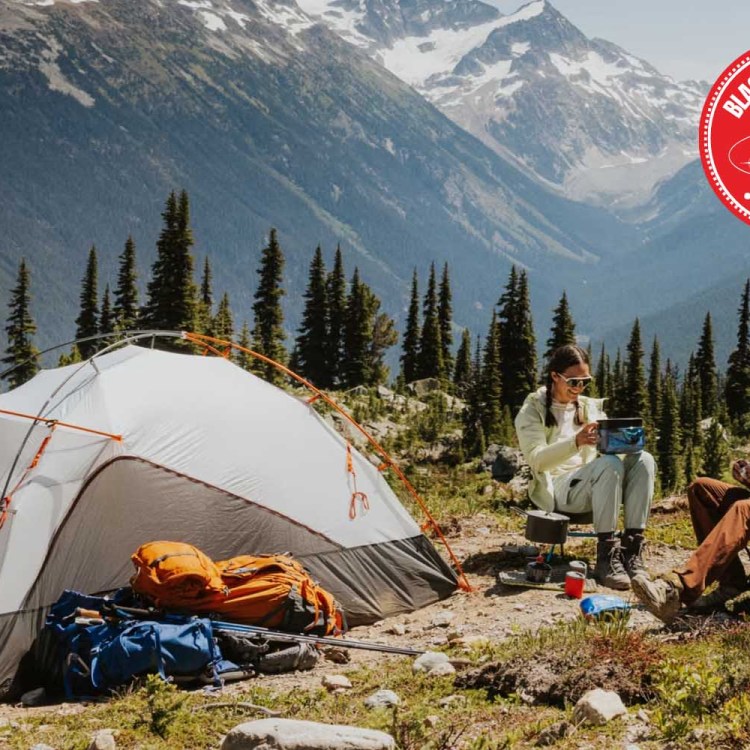 Two people camping near a mountain.